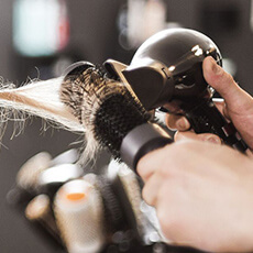 Brushing professionnel réalisé avec brosse ronde et sèche-cheveux au Salon Maël Coiffure Strasbourg.