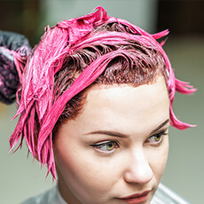 Application d’une coloration rose tendance sur les cheveux d’une cliente à Strasbourg.