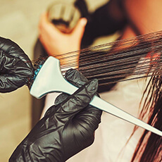 Application d’un soin nourrissant au pinceau par un coiffeur professionnel à Strasbourg.